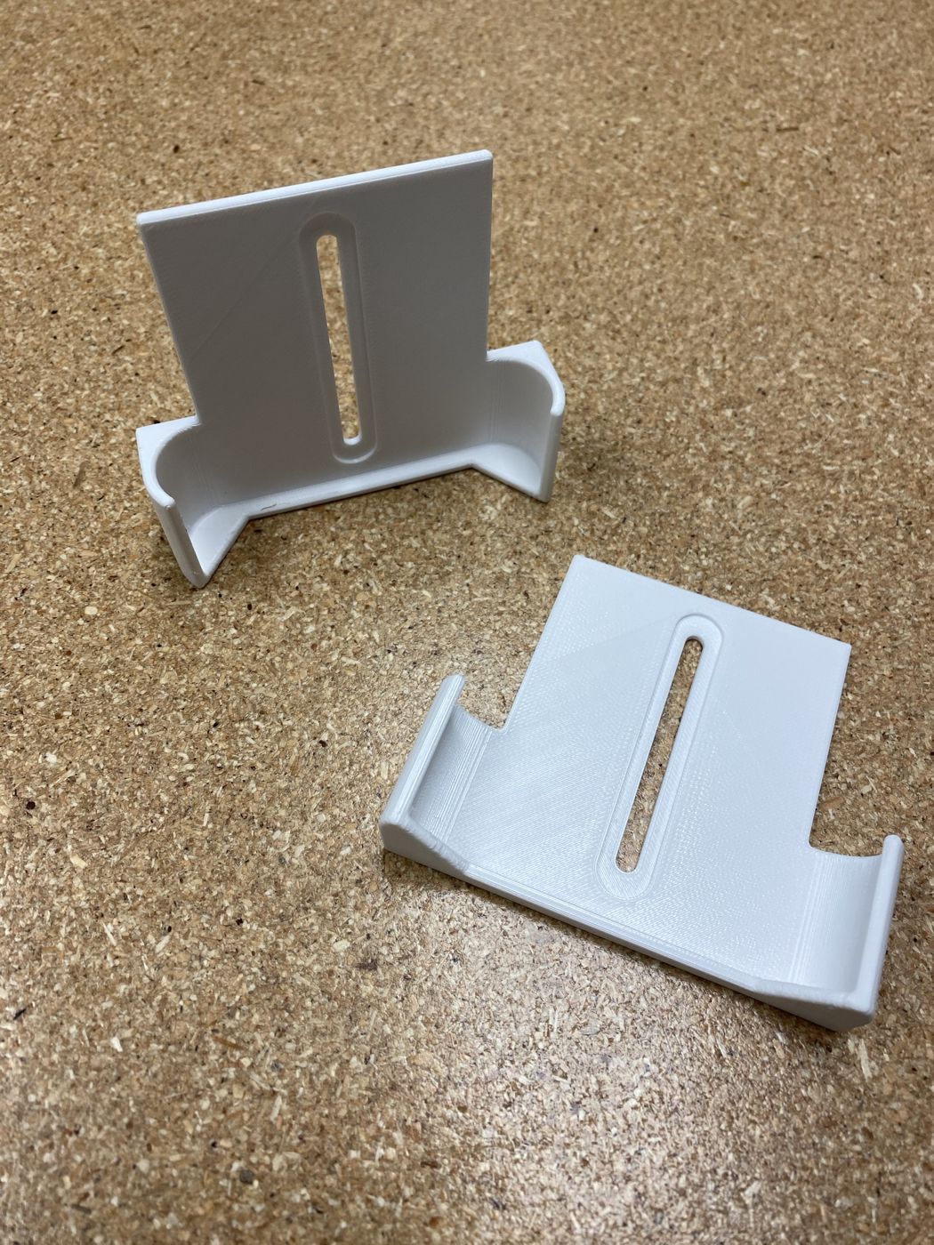 Two 3D-printed white brackets