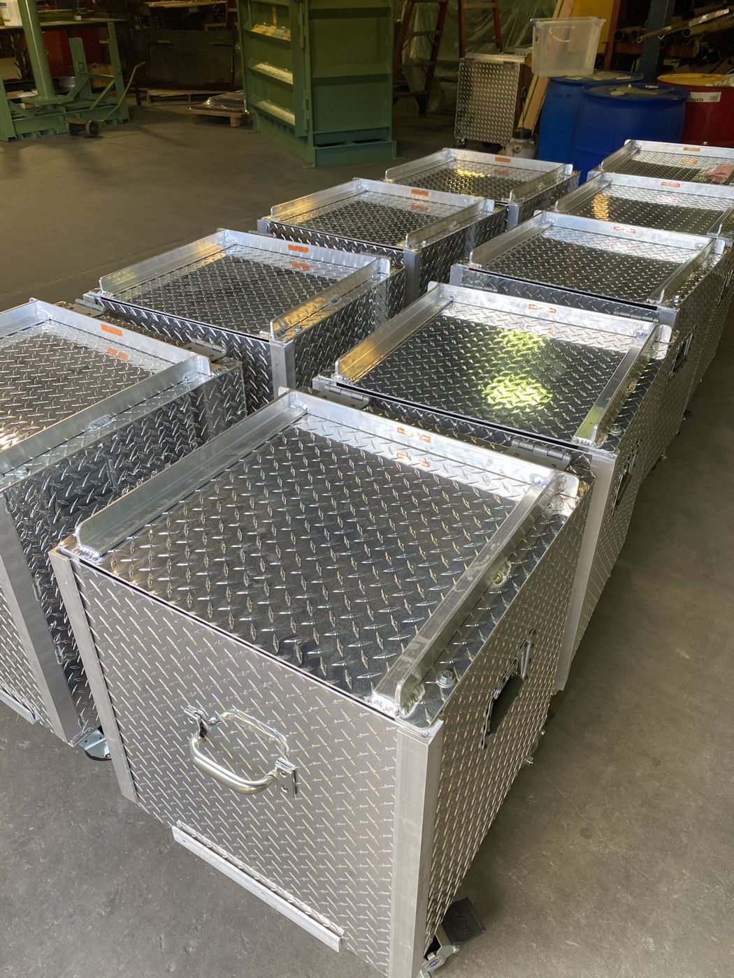 A row of aluminum diamond-plate boxes on casters