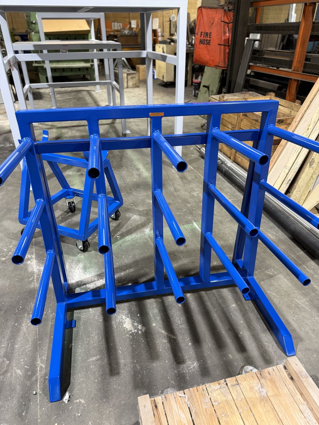 A blue welded steel storage rack with tube arms