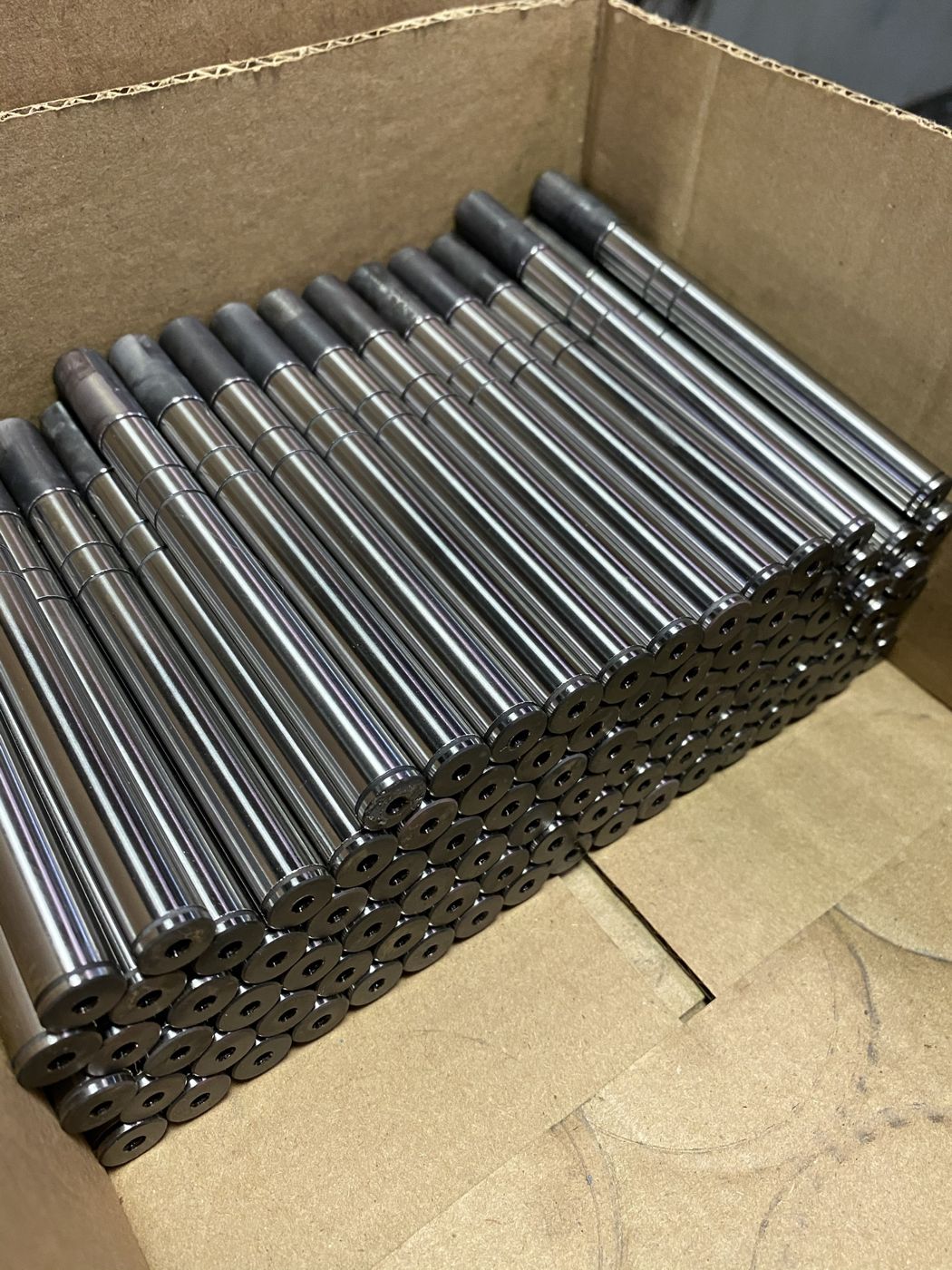 A box of machined steel pins