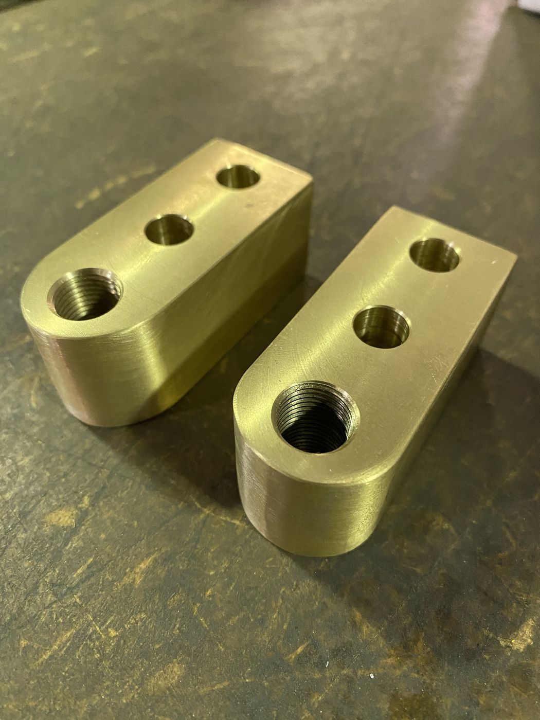 Two drilled and tapped bronze blocks