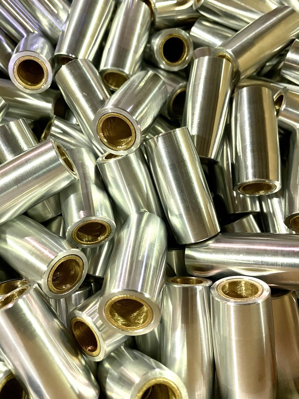 A pile of steel bushings with bronze liners