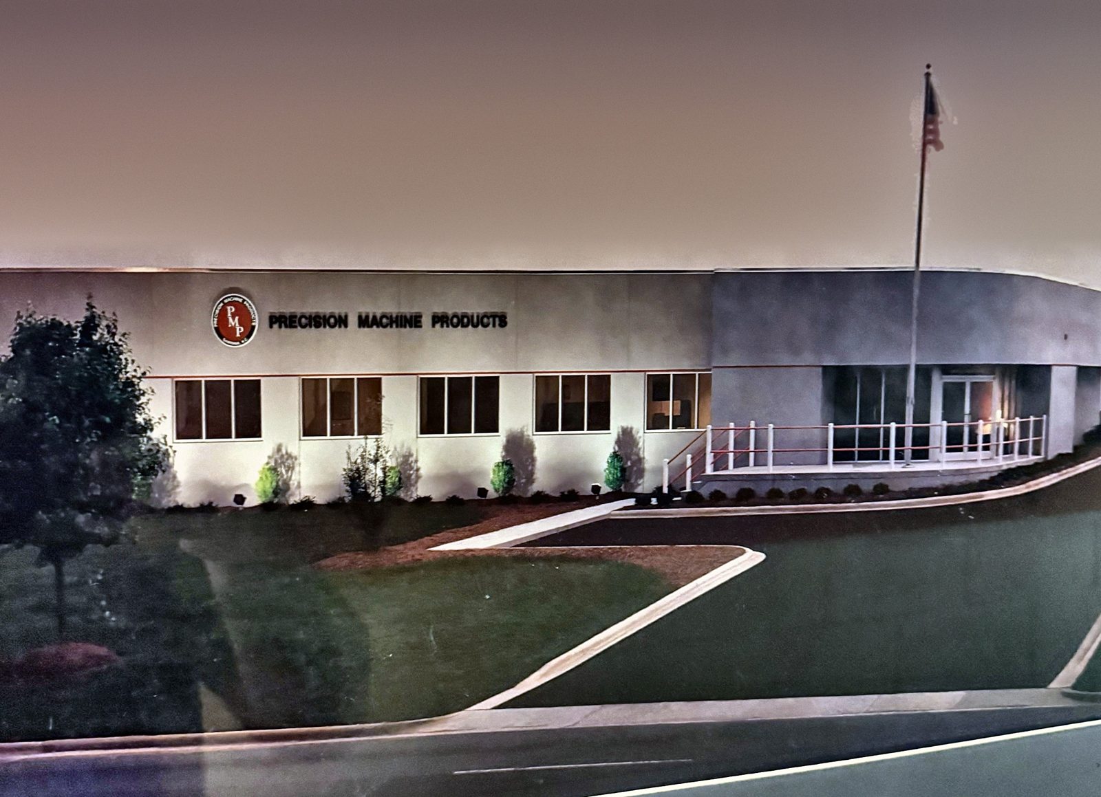 Front of the current Precision Machine Products building with the PMP logo and flagpole