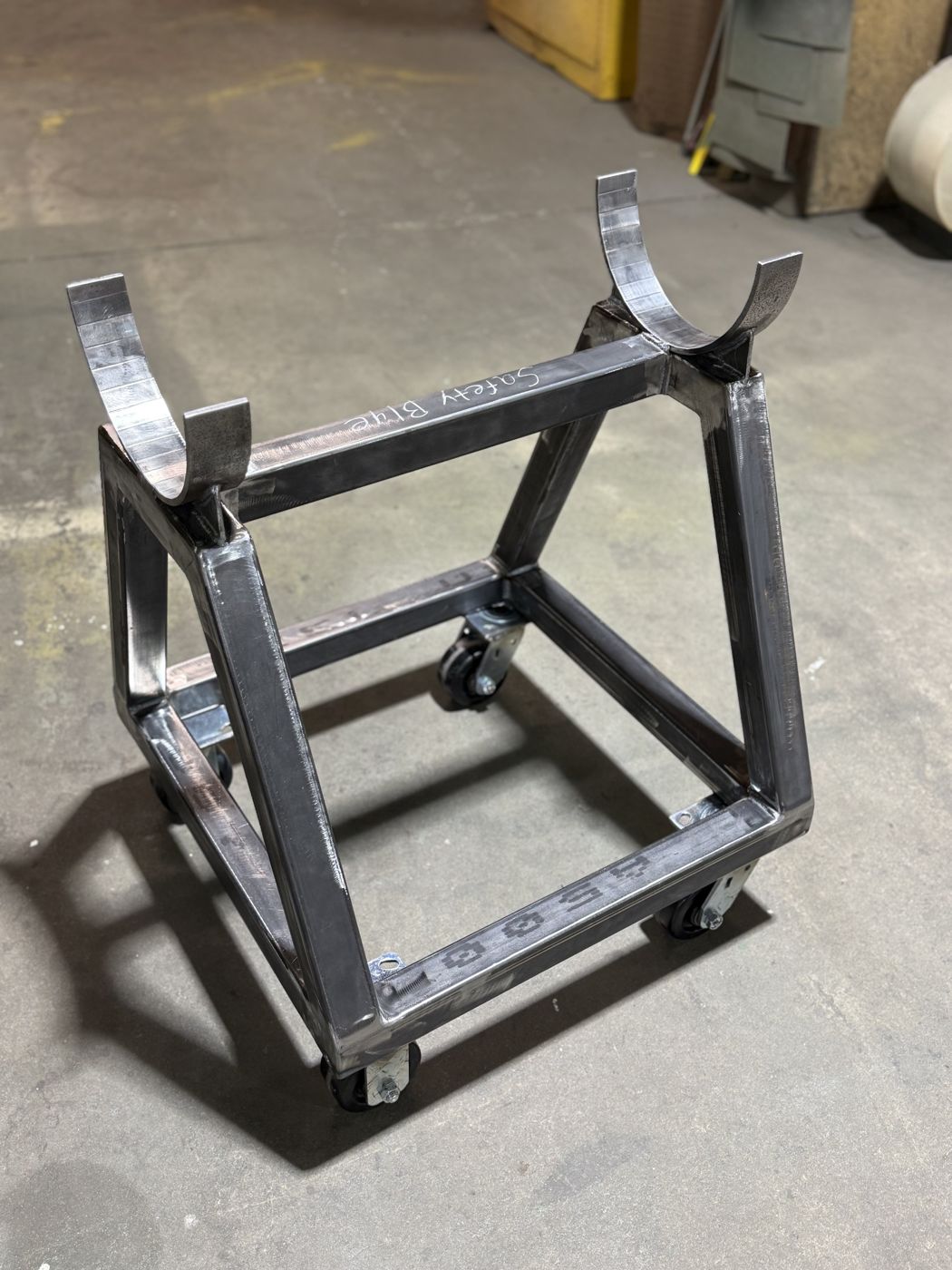 A bare welded steel cradle cart on casters
