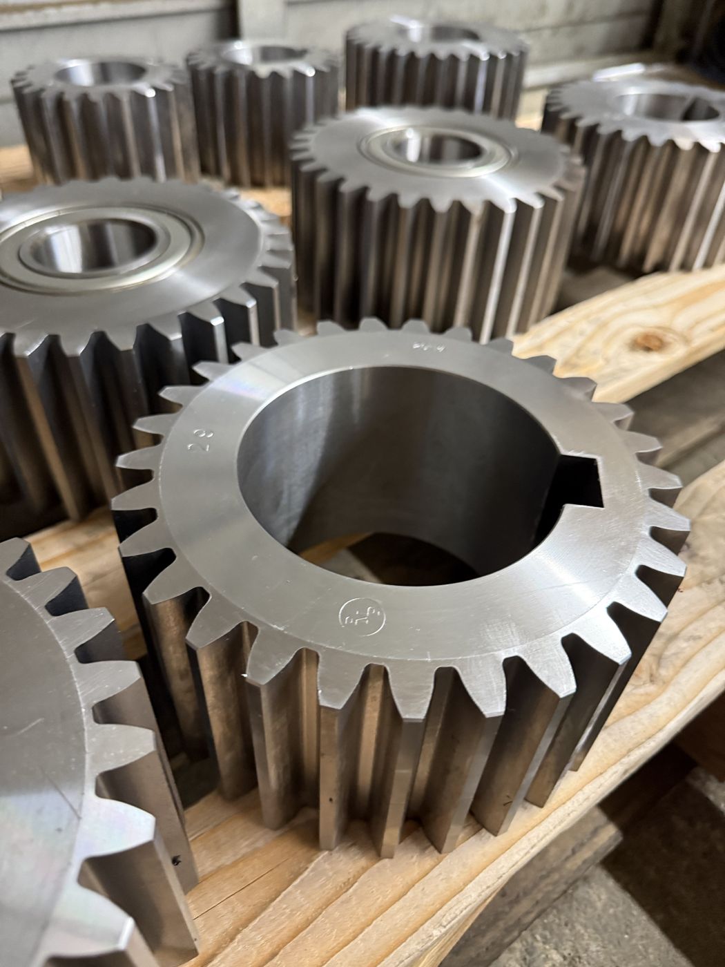 Large machined steel spur gears on a pallet