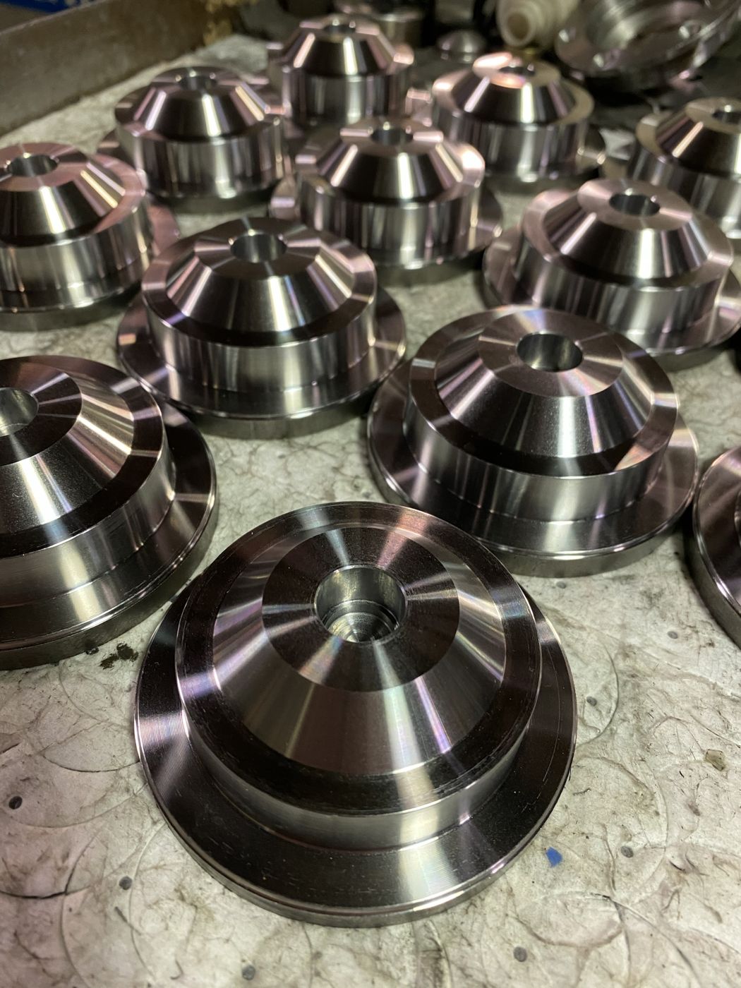 Rows of machined steel parts with conical tops