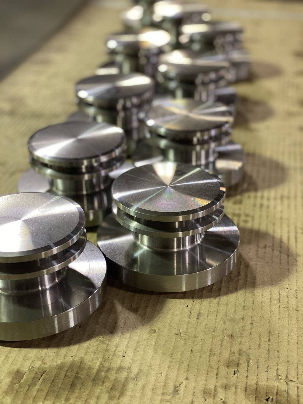 Machined steel parts lined up on a bench